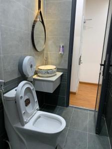 a bathroom with a toilet with a mirror and a sink at Khải Hoàn Hotel in Bến Cát