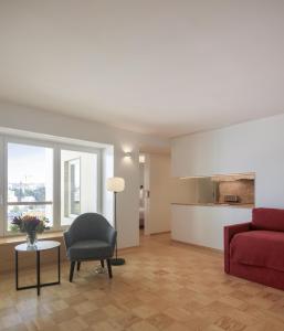 ein Wohnzimmer mit einem roten Sofa und einem Stuhl in der Unterkunft Lisbon Serviced Apartments - Principe Real in Lissabon