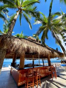 a bar on the beach with palm trees at Costa Sur Resort & Spa in Puerto Vallarta