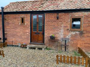 a brick house with a wooden door on it at Cute mini-studio in Blythburgh in Blythburgh