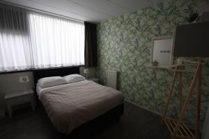um quarto de hotel com uma cama e uma televisão em 4 persoons appartement - ook te boeken voor 6 personen! em Bakkeveen