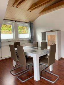 ein Esszimmer mit einem weißen Tisch und Stühlen in der Unterkunft Ferienwohnung am Rothenberg in Altenau