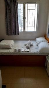 a bed with two pillows and a window in a room at 志城住房 in Hong Kong