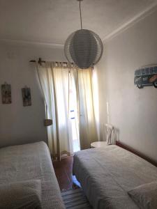 una camera da letto con due letti e una grande finestra di Cliff House next to beach a Ericeira