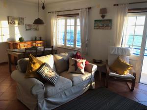 un soggiorno con un divano e un tavolo di Cliff House next to beach a Ericeira