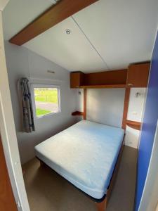 a small room with a bed and a window at Camping La Baie du Mont Saint Michel in Céaux