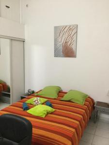 1 dormitorio con 1 cama grande con almohadas verdes en ALLEGRO, en Pointe-à-Pitre