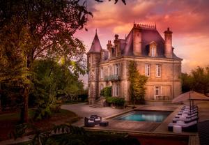 an old mansion with a swimming pool in front of it at Le Château des Tourelles en Vendée in La Gaubretière