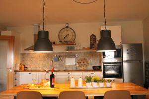 a kitchen with a wooden table with three lights at Casa Aldeia da Lapa in Sernancelhe