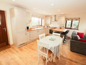 a kitchen and living room with a table and chairs at Bodneithior in Llandyfrydog