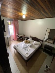 a bedroom with a large bed and a mirror at Hotel Rota Do Mar Inn Itajaí Navegantes in Itajaí