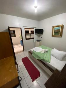 a bedroom with a large bed with a red rug at Hotel Rota Do Mar Inn Itajaí Navegantes in Itajaí +25 photos