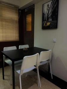 a dining room table with white chairs and a black table at Oasis Apartments in Hong Kong