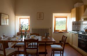 a kitchen with a table and chairs and a kitchen with a table and a table at Quercia Al Poggio in Barberino di Val dʼElsa