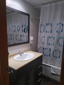 a bathroom with a sink and a shower curtain at Apartamentos Rosi in Benicarló
