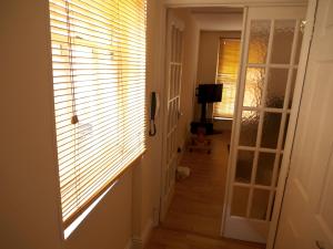 a hallway with a window with blinds on it at Mayfair Flat in London
