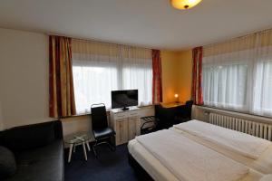 una camera d'albergo con letto e TV di Hotel Wiedenhof a Hilden