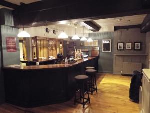 un bar en un restaurante con taburetes en Original White Hart, Ringwood by Marston's Inns, en Ringwood