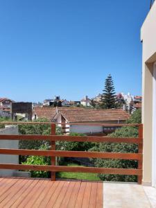 a wooden fence on a deck with a view of a city at Complejo Marce in Ostende