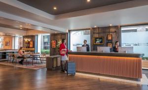 a man standing in front of a restaurant with a counter at Clayton Hotel City of London in London