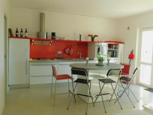 a kitchen with red cabinets and a table and chairs at Casa Gunnarsson in Pizzo
