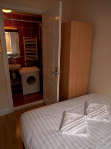 1 dormitorio con 1 cama y baño con lavadora. en Mayfair Flat, en Londres