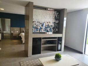 a living room with a large screen in a hotel room at Capão do Cerrado Pousada e Spa in Itabirito