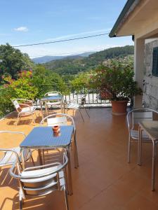 a patio with tables and chairs and a view at hostel do Ermal in Vieira do Minho