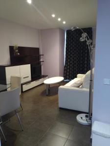 a living room with a white couch and a table at Apartamentos Rosi in Benicarló