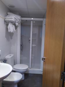 a bathroom with two toilets and a glass shower at Apartamentos Rosi in Benicarló