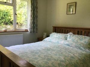 um quarto com uma cama e uma janela em Wingmore em Salisbury