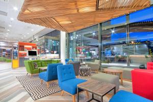 a lobby with colorful chairs and tables in a store at Holiday Inn Helsinki West - Ruoholahti by IHG in Helsinki