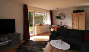 ein Wohnzimmer mit einem Sofa und einem TV in der Unterkunft Alpenflair Ferienwohnungen Whg. 309 Himmelschrofen in Oberstdorf