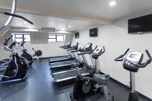 a gym with a row of treadmills and cardio machines at Holiday Inn Auckland Airport by IHG in Auckland