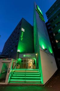 un edificio con luci verdi davanti di Holiday Inn Clermont Ferrand Centre, an IHG Hotel a Clermont-Ferrand