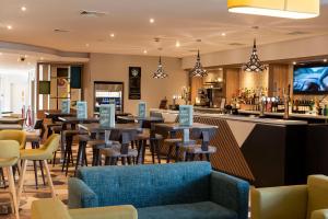 a restaurant with tables and chairs and a bar at Holiday Inn Birmingham M6, Jct7 by IHG in Birmingham