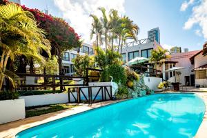 a swimming pool in front of a building with palm trees at Moriah Natal Beach Hotel in Natal