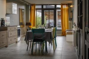 une cuisine avec une table et des chaises dans l'établissement Chambres D´Hôtes Herbes Folles, à Steenwerck