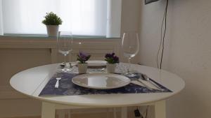 - une table blanche avec une assiette et deux verres à vin dans l'établissement Encantador apartamento en el corazón de Sevilla, à Séville