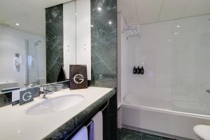 ein Badezimmer mit einem Waschbecken, einer Badewanne und einem Waschbecken in der Unterkunft Hotel Barcelona Universal in Barcelona