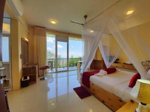 a bedroom with a canopy bed and a balcony at Hotel Ella`s Edge in Ella