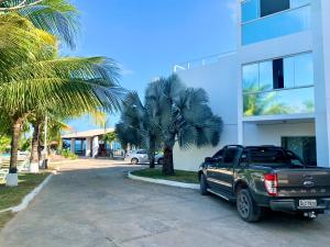 馬塞約的住宿－Pousada Paradise Vista do Atlantico，停在棕榈树建筑前面的卡车