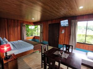 ein Schlafzimmer mit einem Bett und einem Tisch in einem Zimmer in der Unterkunft Cabañas Sueños del Arenal in Fortuna