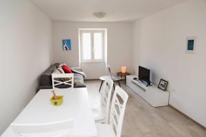 a white living room with a table and a couch at NEW LUXURY APARTMENT SANDRA- OLD TOWN KORCULA in Korčula