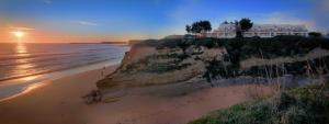 a building on a cliff next to the ocean at Villas Flamenco Beach Conil in Conil de la Frontera