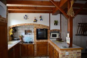 uma cozinha com armários de madeira e uma bancada em MARAIS POITEVIN gite "volets bleu clair" pêche ,barque, vélos, wifi, linge, cheminée, cuisine, terrain de boules em La Taillée