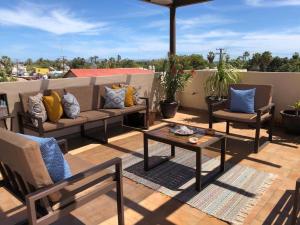 a patio with a couch and chairs and an umbrella at Bugambilias Suites in Loreto