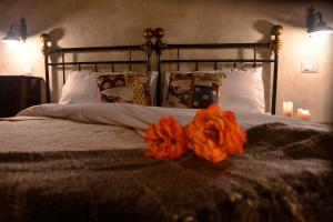 un letto con decorazioni arancioni sopra di Robur Marsorum Albergo Diffuso a Rocca di Mezzo