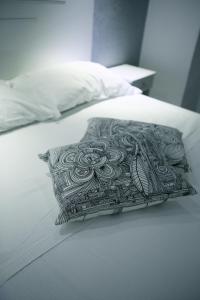 a black and white pillow on a white bed at Arts & Rooms in Rome