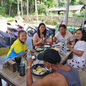 a group of people sitting at a table eating food at Mateoasis in Ko Kood